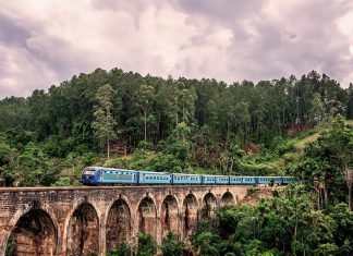 Tren azul cruzando un puente con arcos de piedra en Sri Lanka