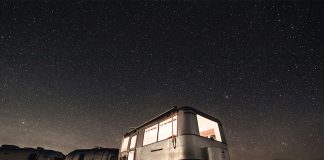 Caravana de noche bajo el cielo estrellado en medio de la naturaleza