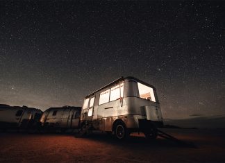 Caravana de noche bajo el cielo estrellado en medio de la naturaleza